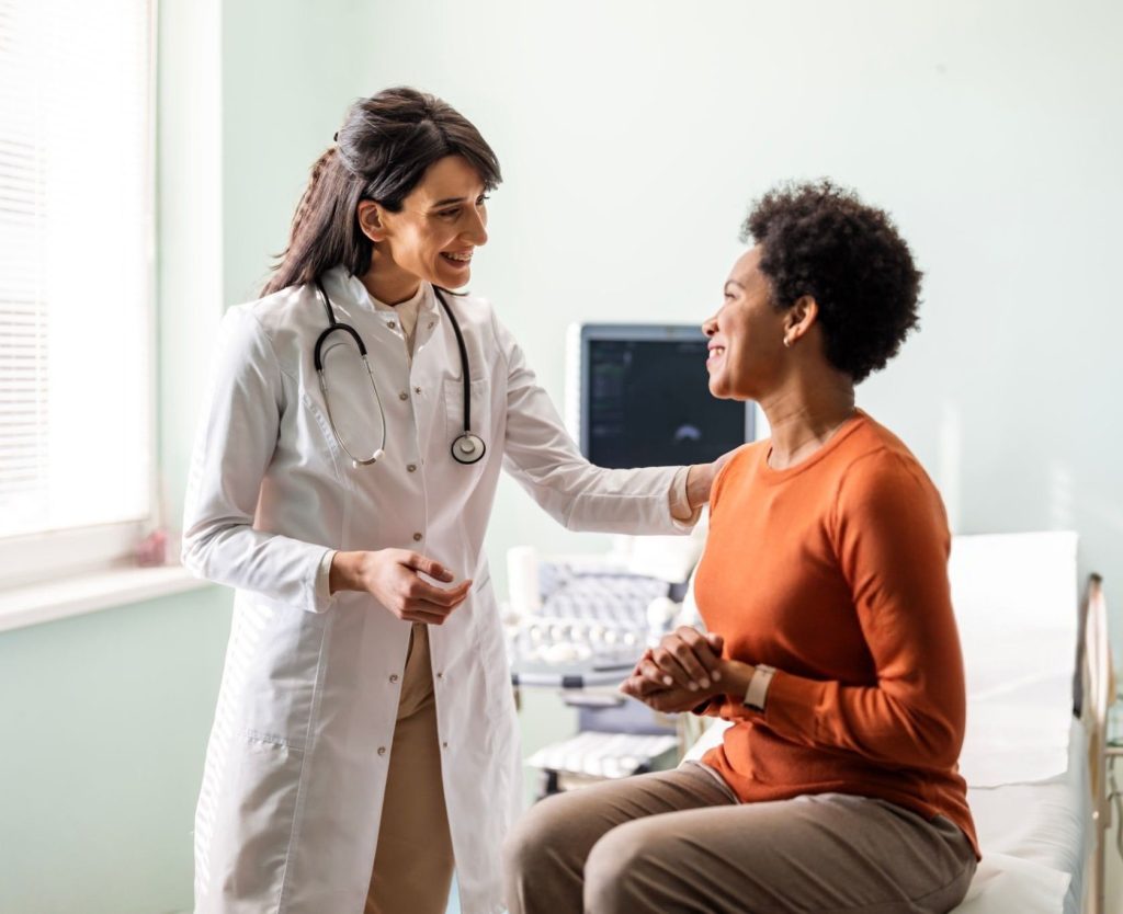 Happy doctor has hand on shoulder of happy patient