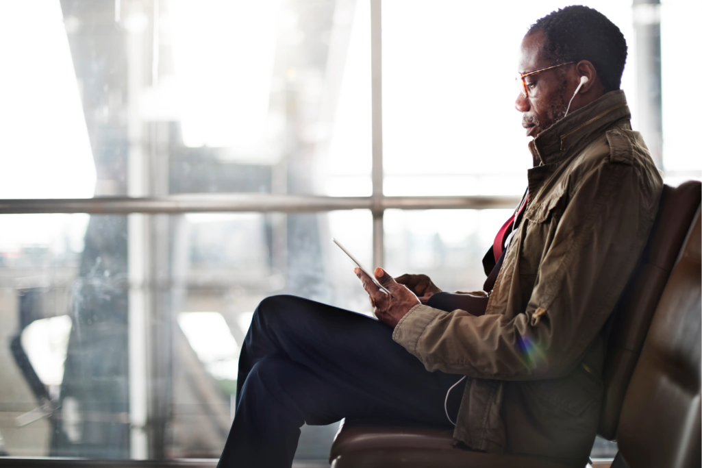 man using a tablet while using earphones